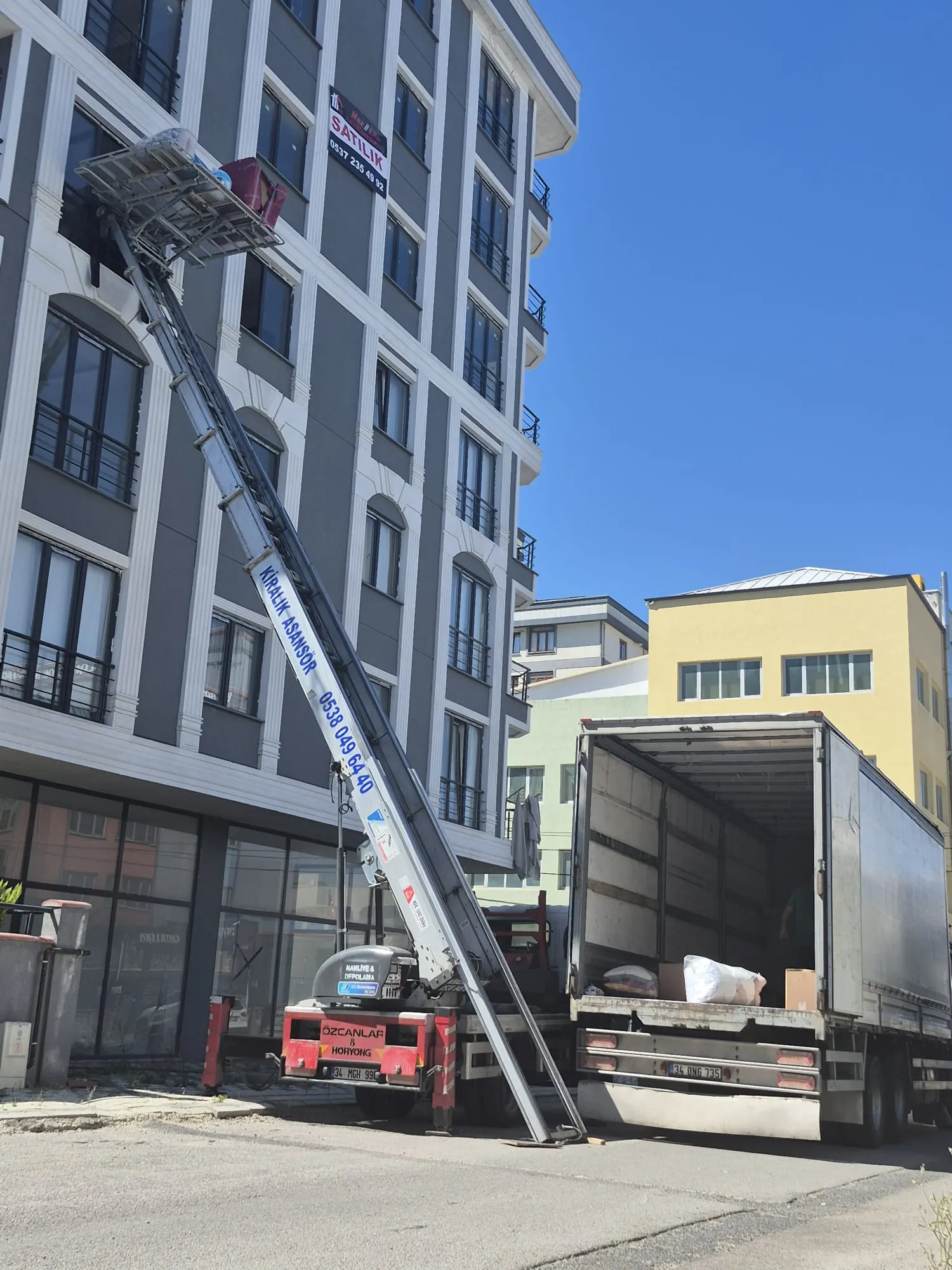 Apartman önünde nakliye aracıyla birlikte kurulan dış cephe mobilya asansörü